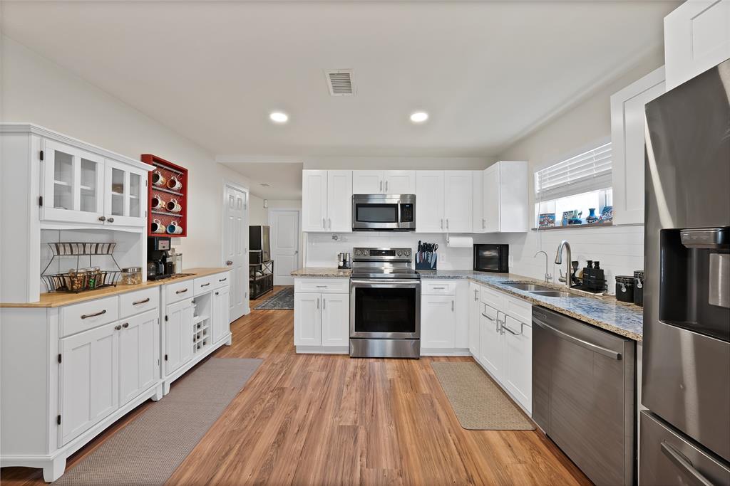 604 Moore Street Garland, TX 75040 - Photo 4 of 26 a kitchen with granite countertop appliances cabinets and a sink