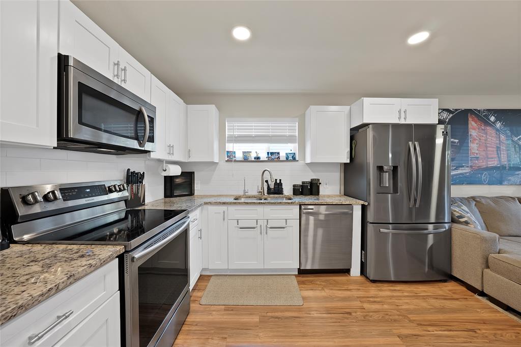 604 Moore Street Garland, TX 75040 - Photo 6 of 26 a kitchen with a stove microwave and refrigerator