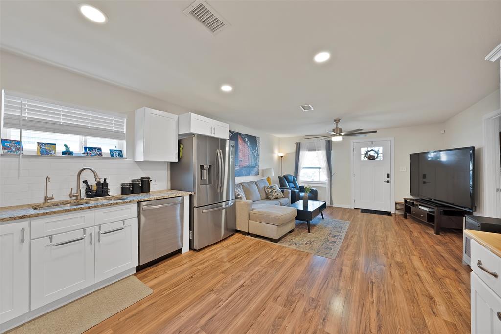 604 Moore Street Garland, TX 75040 - Photo 7 of 26 a open kitchen with stainless steel appliances granite countertop a stove and white cabinets with wooden floor