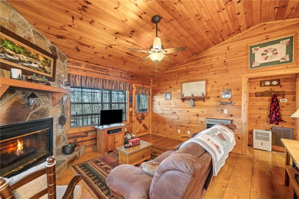 301 Laurel Creek Road Blue Ridge, GA 30513 - Photo 13 of 36 a living room with furniture a flat screen tv and a fireplace