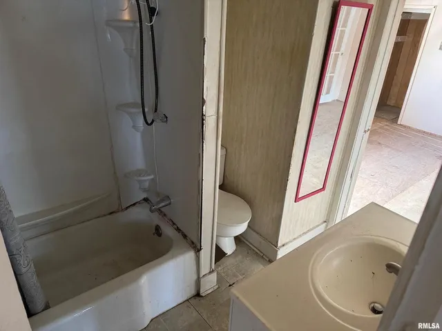a bathroom with a tub a toilet and a sink