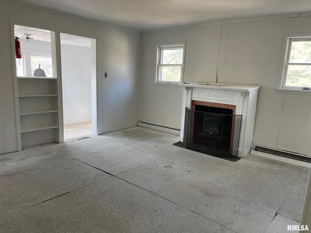 an empty room with a fireplace and windows