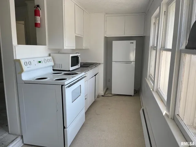 a kitchen with a stove cabinets and a refrigerator