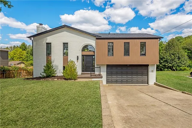 a view of a house with brick walls and a yard with plants