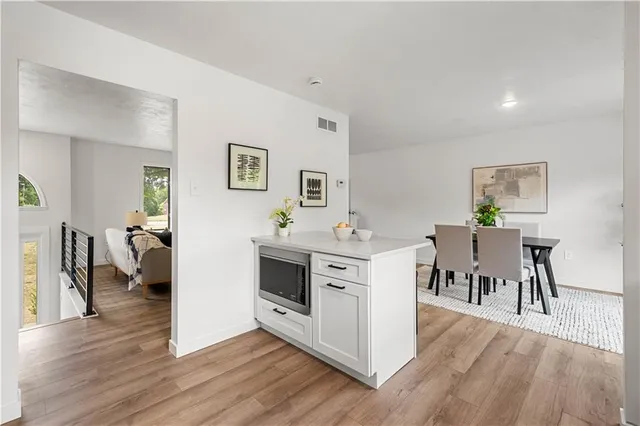 a kitchen with white cabinets appliances and a window