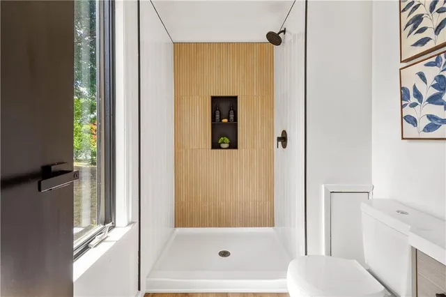 a bathroom with a sink a toilet and shower