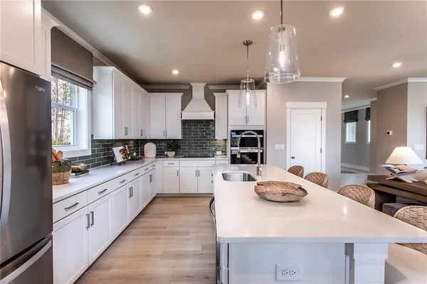 a large kitchen with kitchen island a sink appliances and cabinets