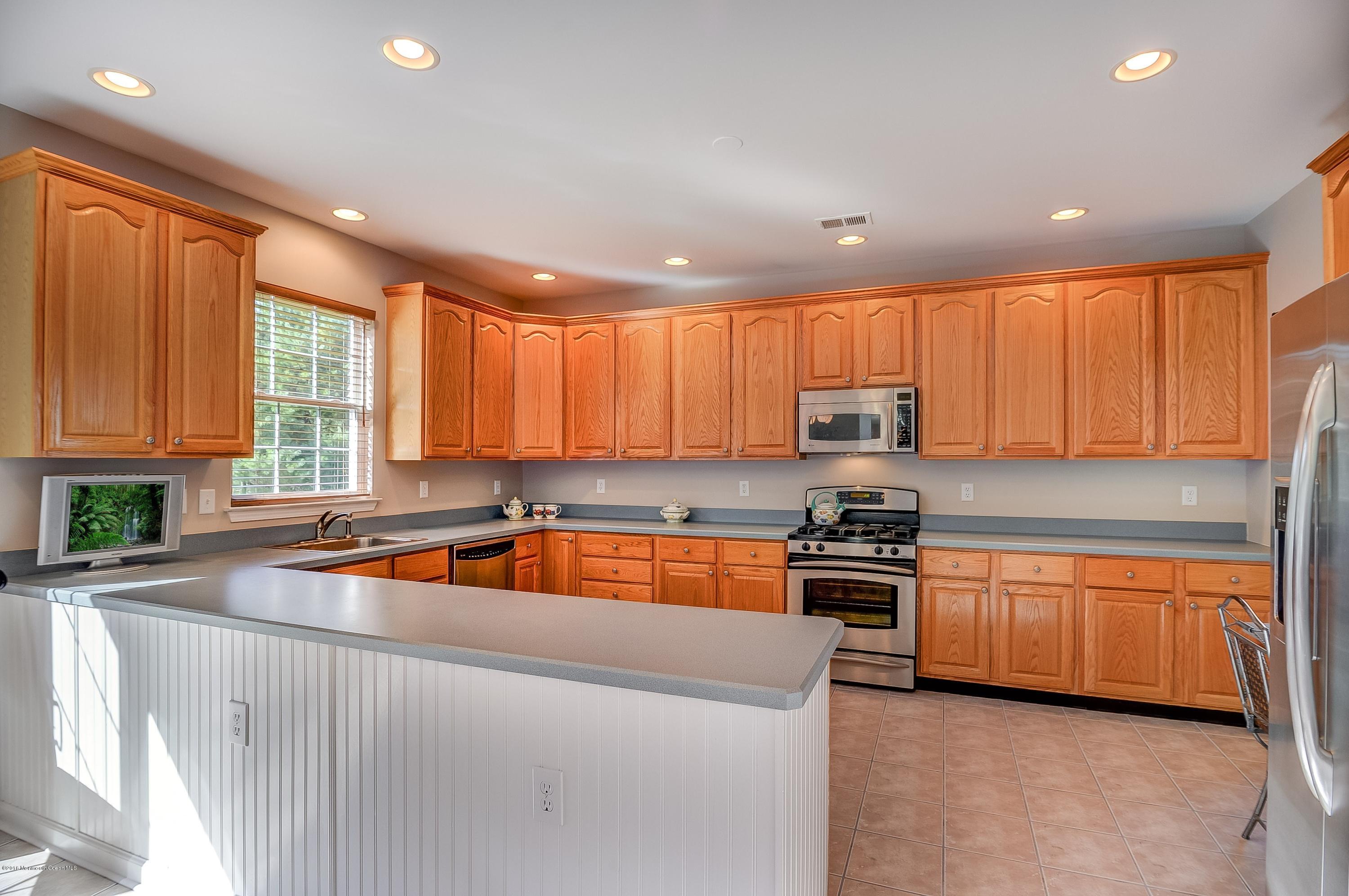 323 Wedgewood Road Morganville, NJ 07751 - Photo 11 of 27 a kitchen with stainless steel appliances granite countertop a stove a sink and a refrigerator