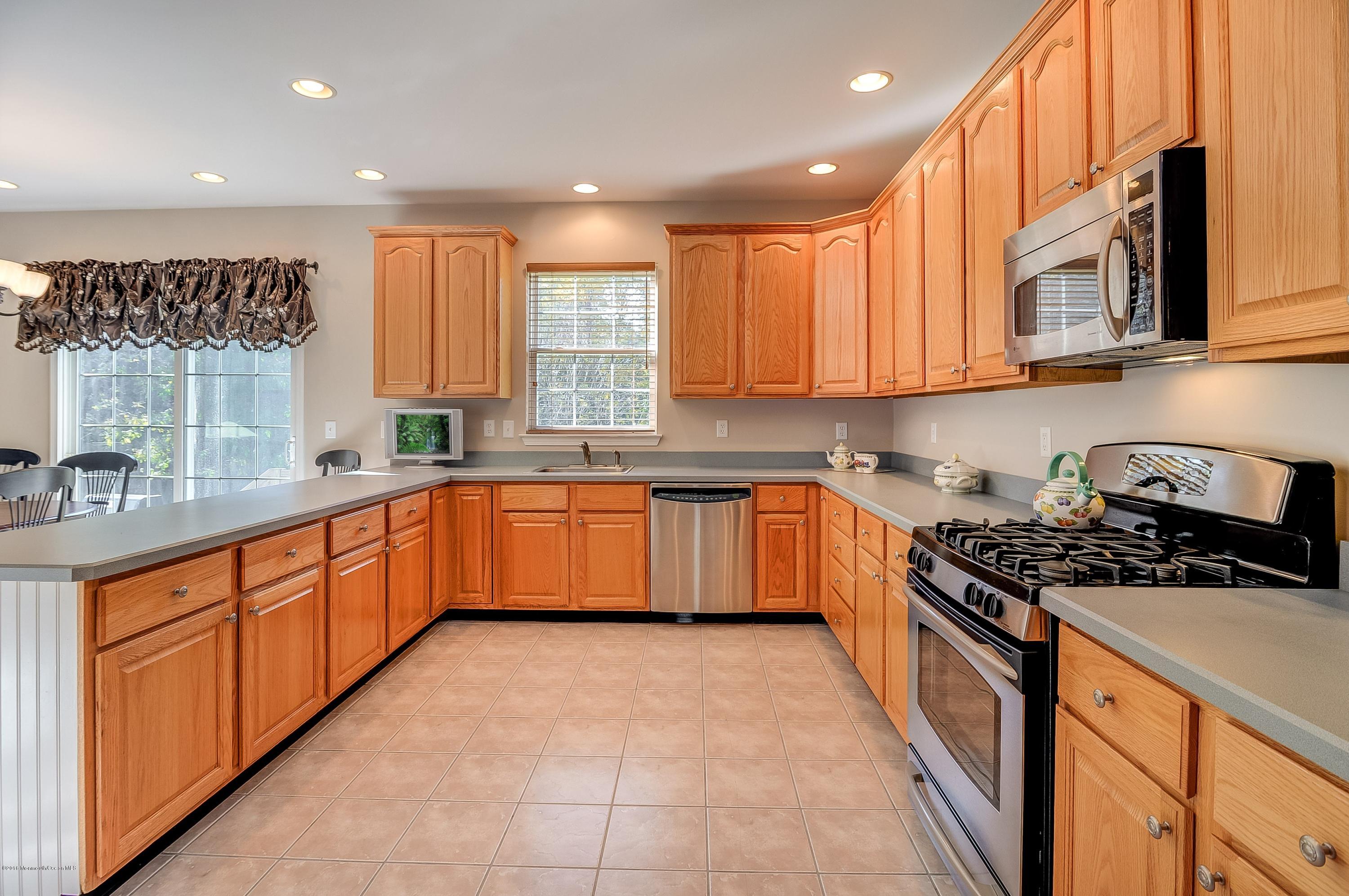 323 Wedgewood Road Morganville, NJ 07751 - Photo 13 of 27 a large kitchen with stainless steel appliances granite countertop a stove a sink dishwasher and a refrigerator
