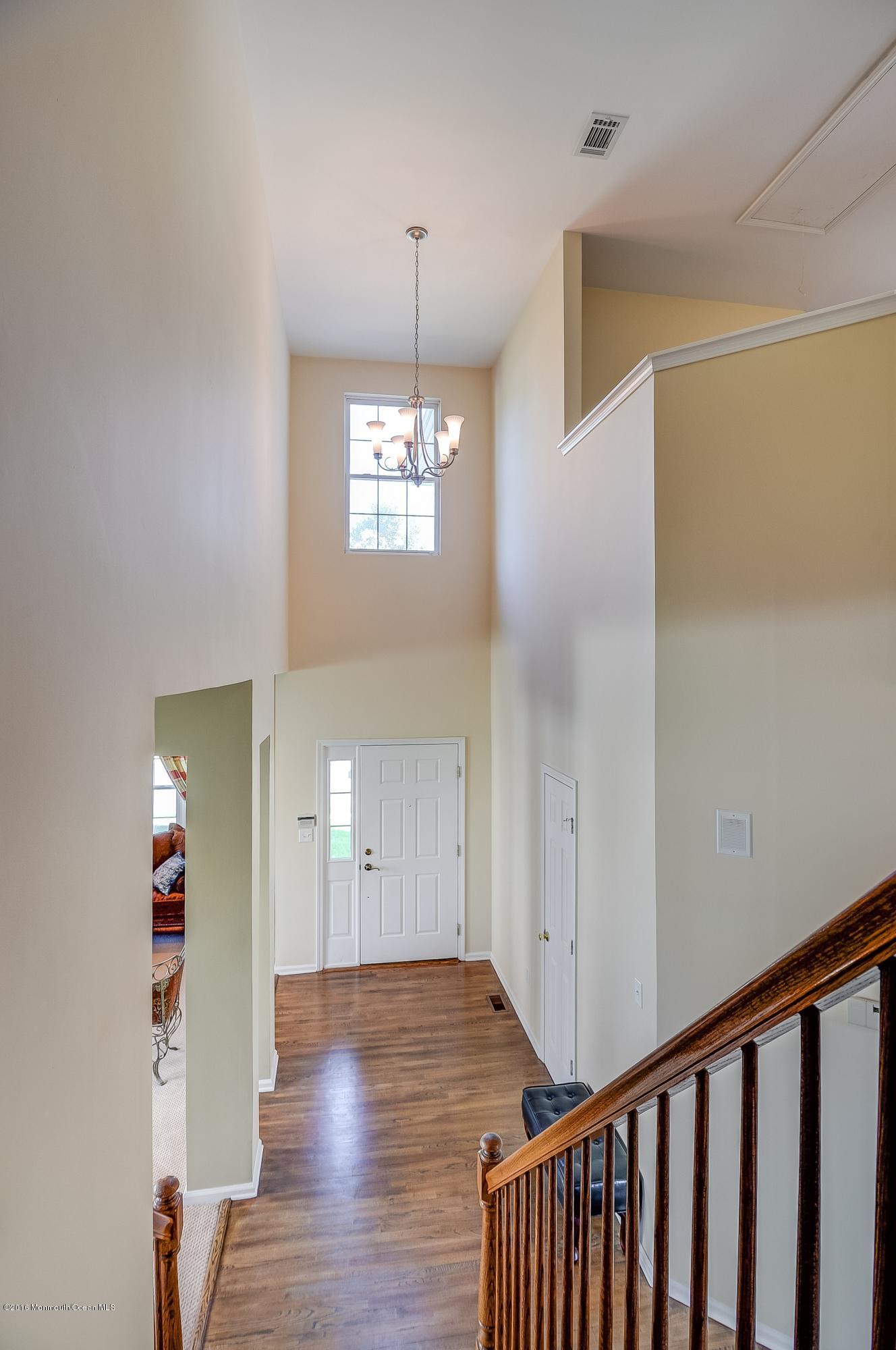 323 Wedgewood Road Morganville, NJ 07751 - Photo 15 of 27 a view of a hallway with wooden floor and a chandelier