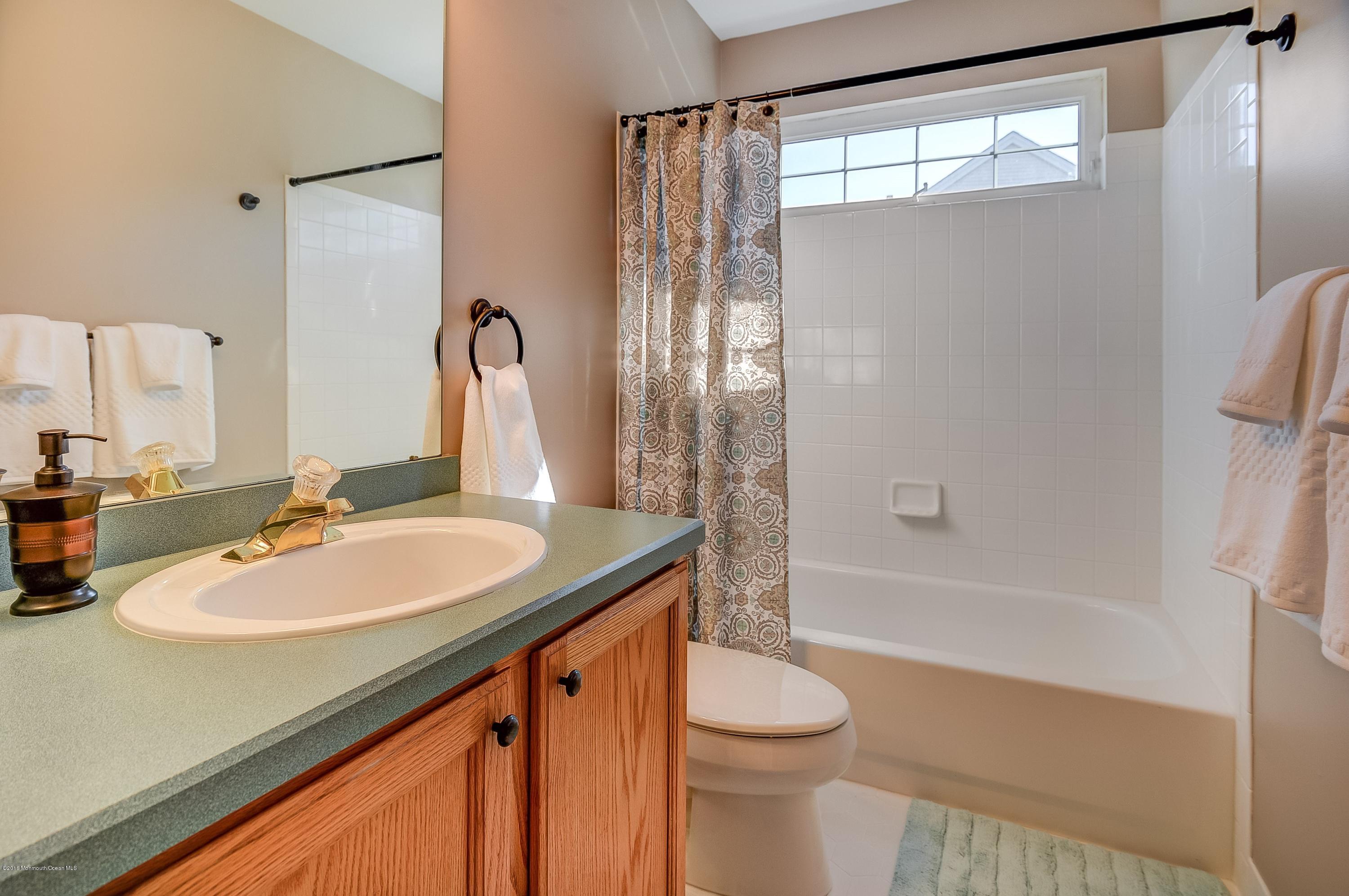 323 Wedgewood Road Morganville, NJ 07751 - Photo 23 of 27 a bathroom with a sink and a mirror