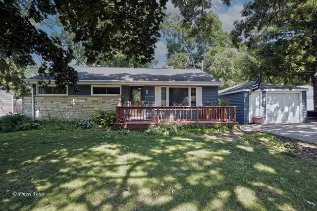 a view of a house with a yard potted plants and large tree