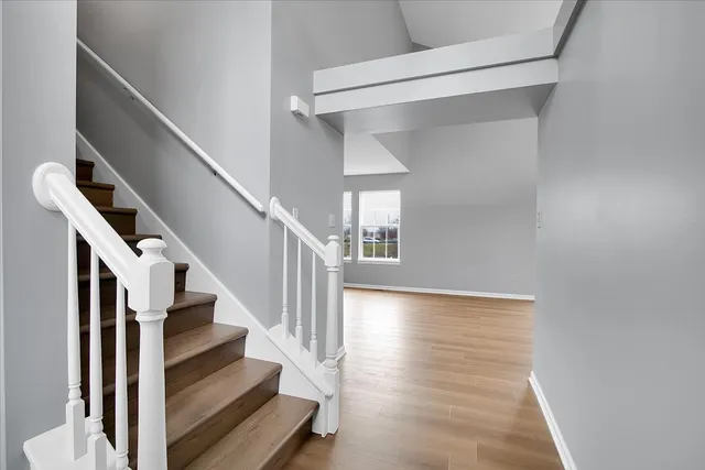 a view of staircase with wooden floor and white walls