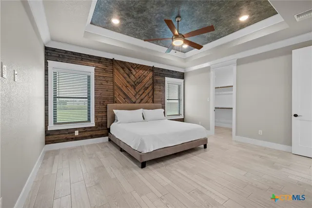 a spacious bedroom with a bed and a ceiling fan