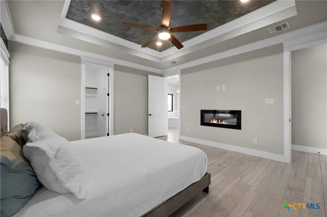 a spacious bedroom with a bed and a chandelier