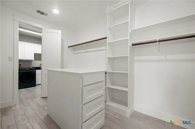 a view of walk in closet with empty racks
