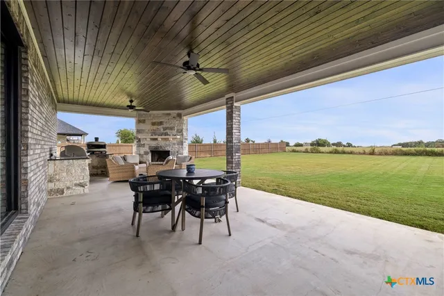 a view of a patio with table and chairs next to an umbrella