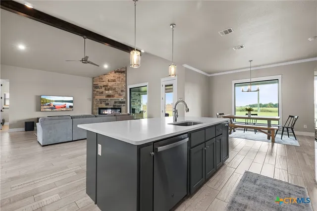a kitchen with lots of counter space a sink appliances and living room view