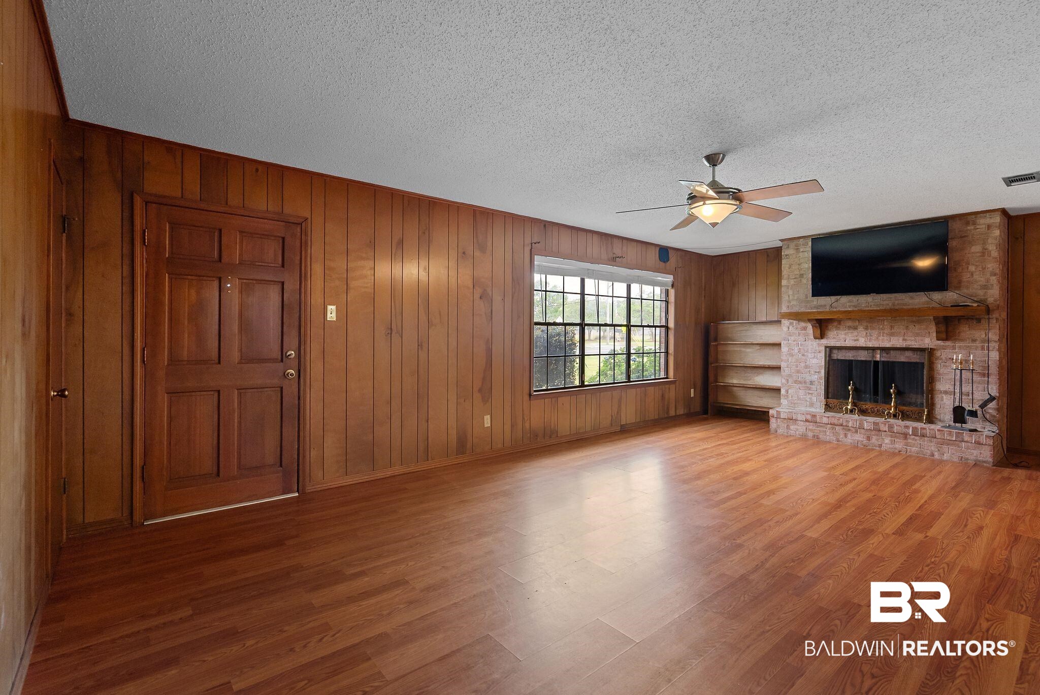 716 North Cedar Street Foley, AL 36535 - Photo 5 of 25 Spacious room featuring wood-finish flooring and wood paneling