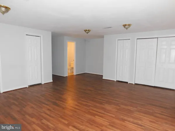 a view of an empty room with wooden floor and entryway