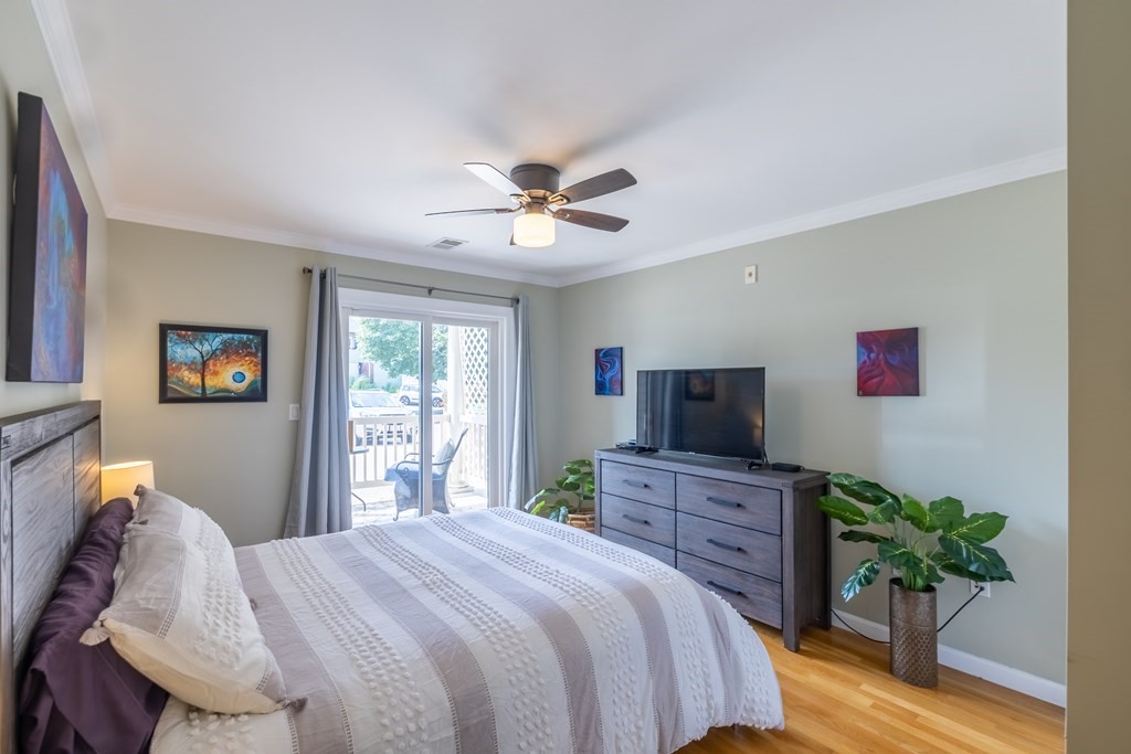 75 Main Street, Unit 102 Amesbury, MA 01913 - Photo 15 of 28 a bedroom with a bed and a flat screen tv