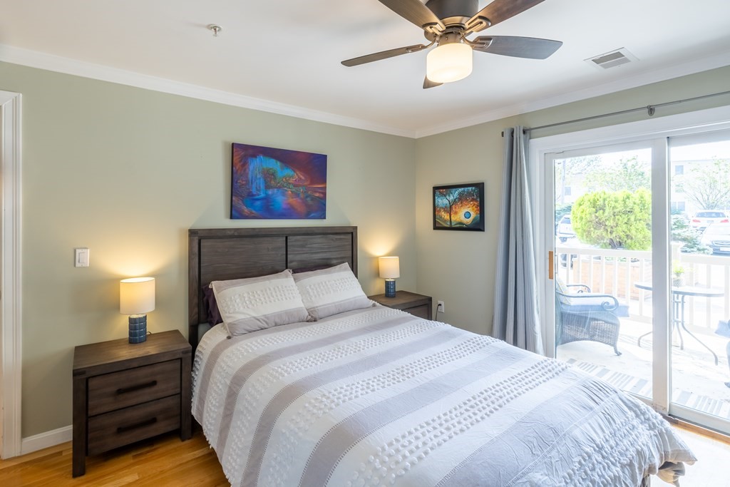 75 Main Street, Unit 102 Amesbury, MA 01913 - Photo 16 of 28 a bedroom with a bed and a chandelier