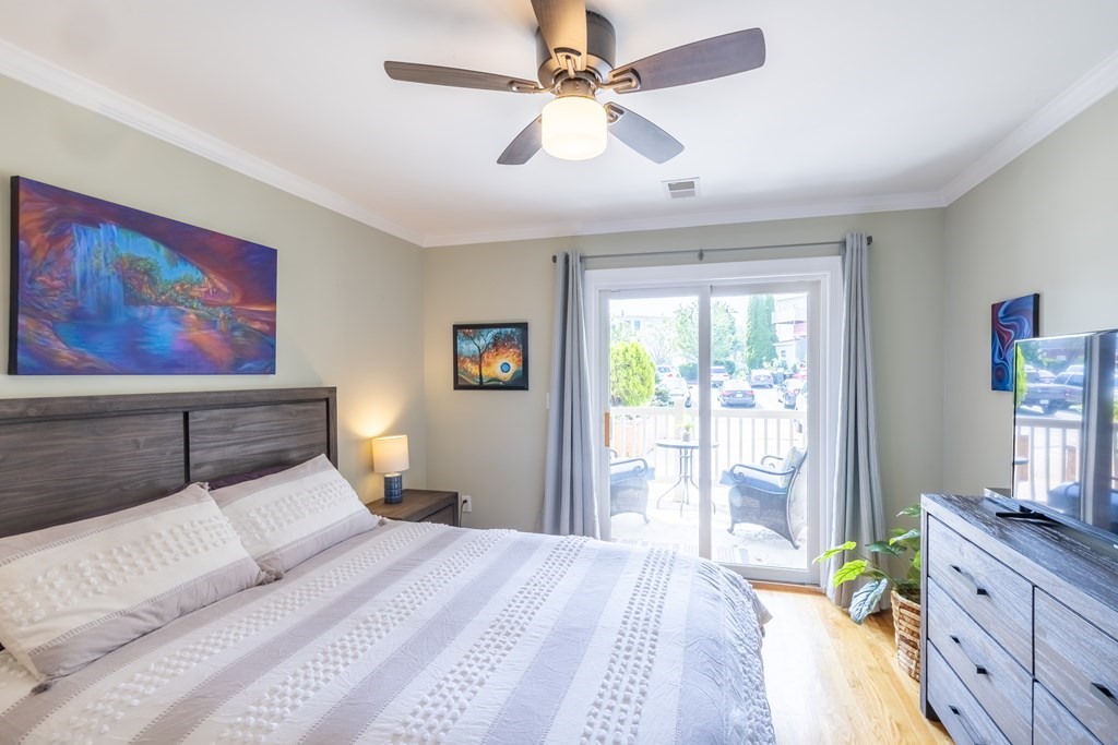 75 Main Street, Unit 102 Amesbury, MA 01913 - Photo 17 of 28 a bed room with a bed and a chandelier