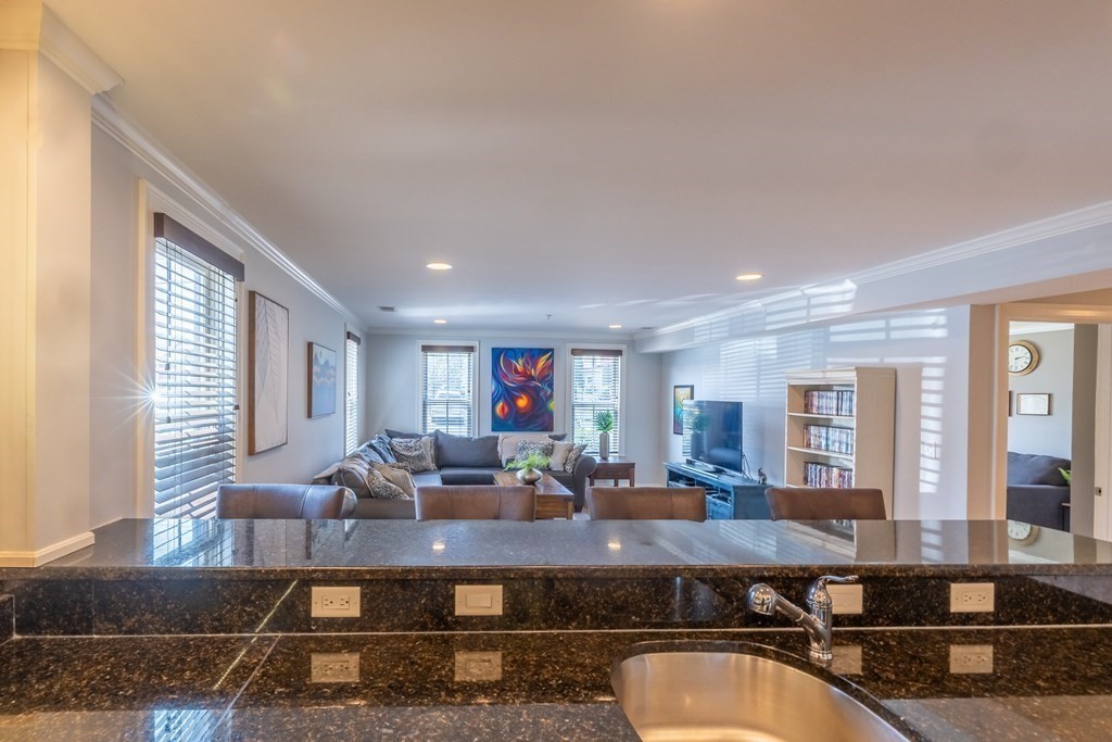 75 Main Street, Unit 102 Amesbury, MA 01913 - Photo 5 of 28 a living room with furniture a large window and potted plant