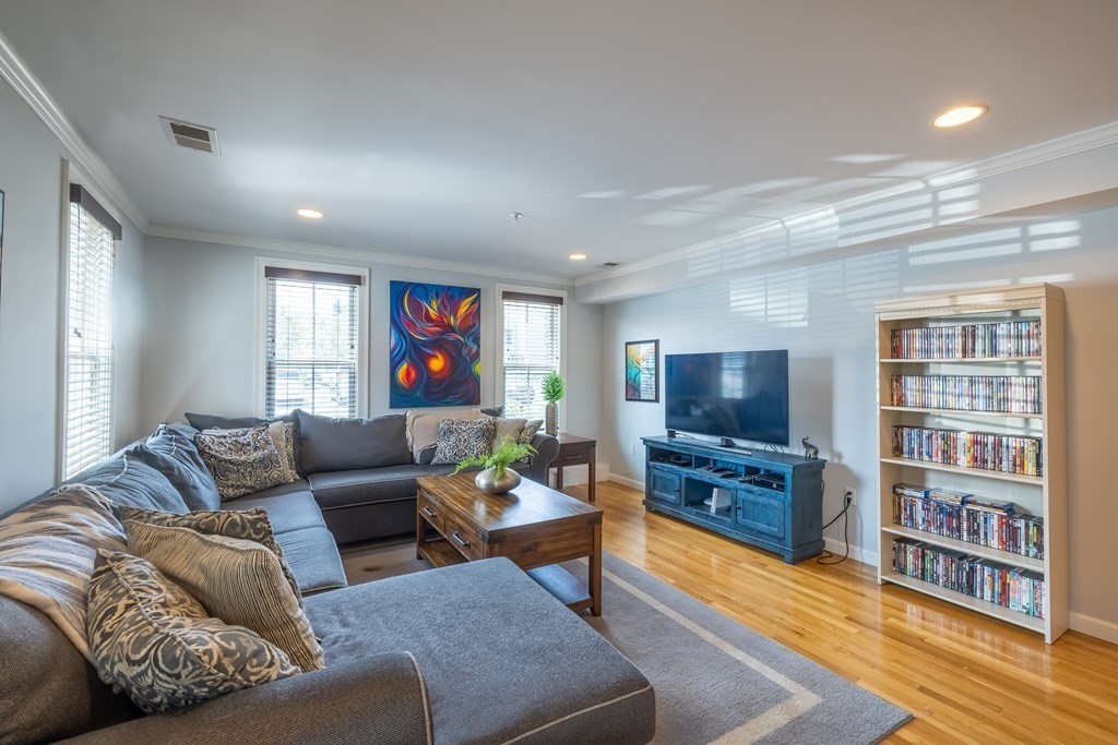 75 Main Street, Unit 102 Amesbury, MA 01913 - Photo 6 of 28 a living room with furniture and a flat screen tv