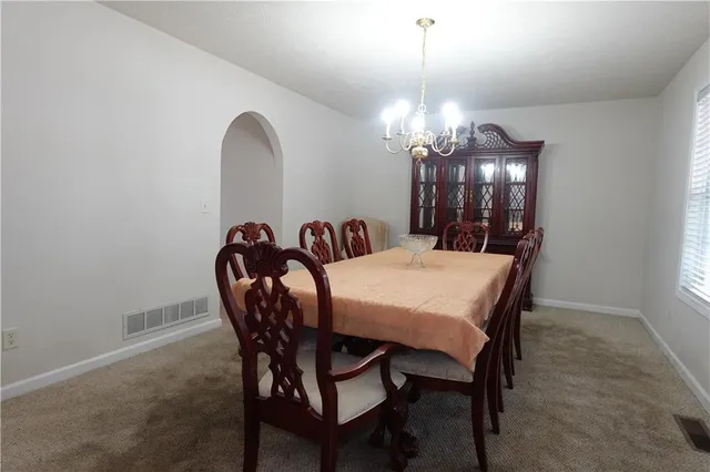 a view of a dining room with furniture and chandelier