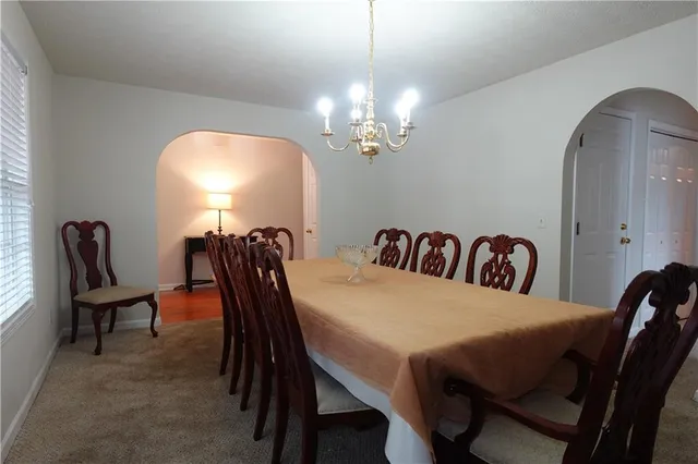 a view of a hallway with a livingroom and a bathroom with sink