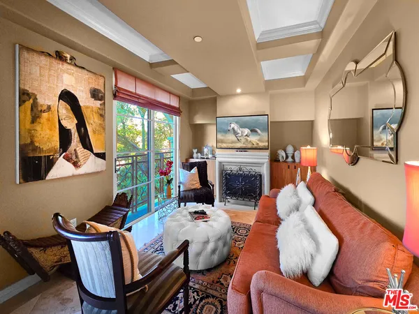 a living room with furniture fireplace and a large window