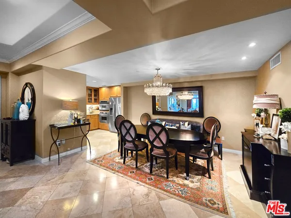 a dining room with furniture a chandelier and kitchen view