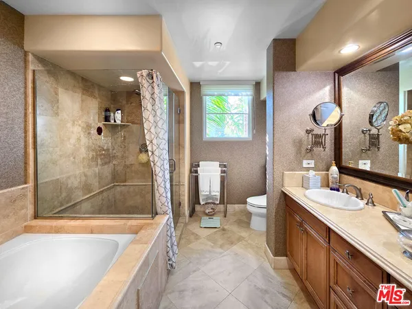 a bathroom with a double vanity sink a toilet a mirror and shower