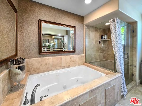 a bathroom with a tub a sink and mirror