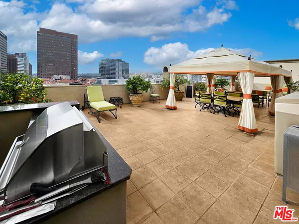 a view of a patio with a table and chairs under an umbrella