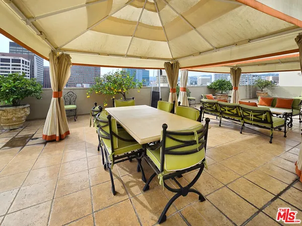 a view of a patio with a table and chairs under an umbrella