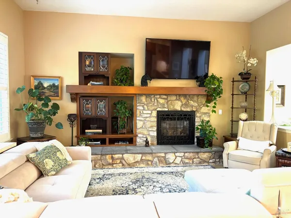 a living room with furniture a fireplace and a flat screen tv
