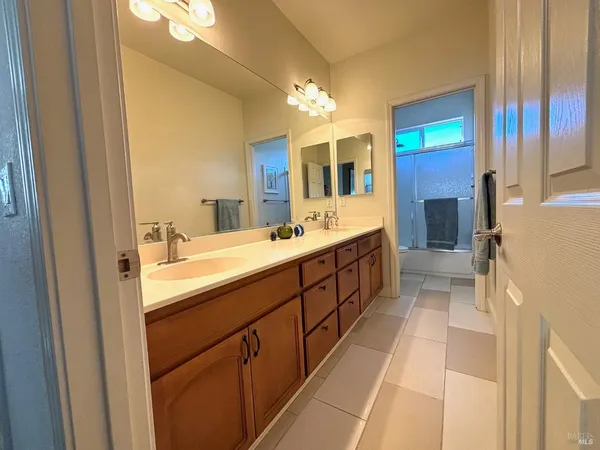 a bathroom with a double vanity sink and a mirror