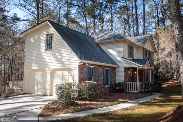a front view of a house with yard and parking