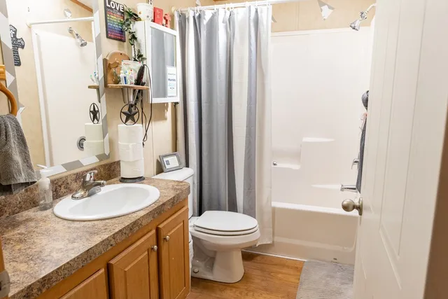 a bathroom with a granite countertop sink toilet and shower