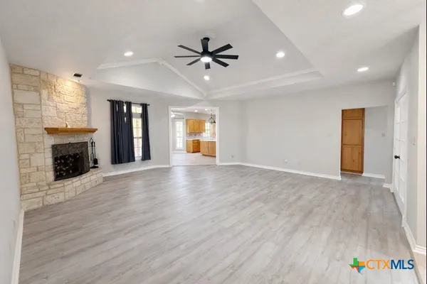 a view of an empty room with a fireplace and a window