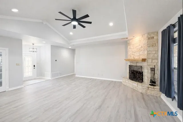 a view of an empty room with a fireplace and a window