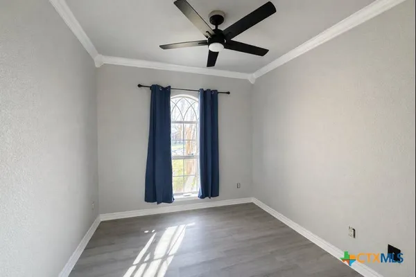 an empty room with a window and a ceiling fan