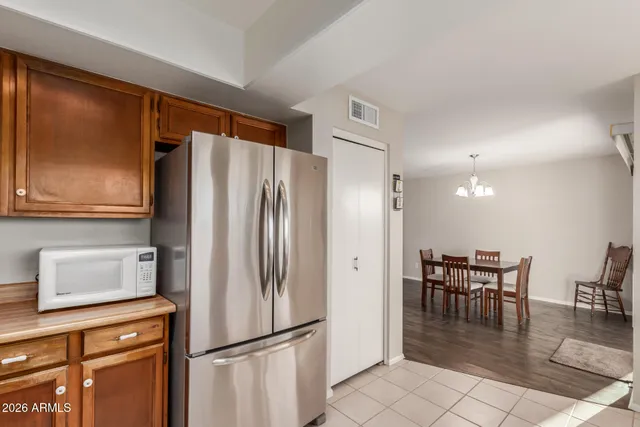 a kitchen with a refrigerator a dining table and chairs