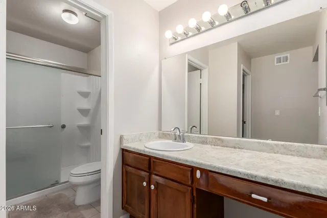 a bathroom with a granite countertop sink toilet and shower