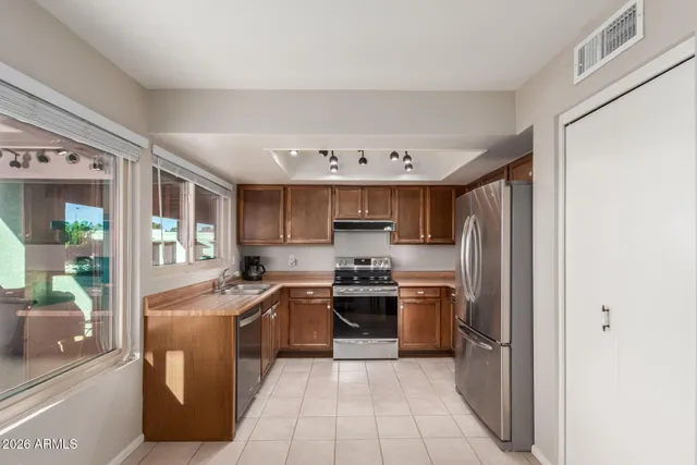 a kitchen with stainless steel appliances granite countertop a refrigerator and a stove top oven
