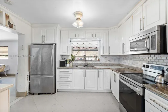 a kitchen with granite countertop a refrigerator stove and microwave