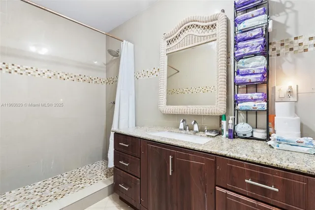 a bathroom with a granite countertop sink and a mirror