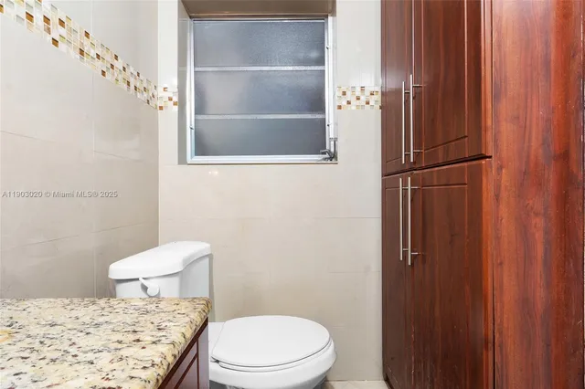 a bathroom with a toilet and a shower curtain